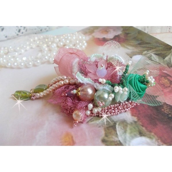 Broche de polvo suave creado con encaje, cinta de organza, cuentas de Swarovski, cuentas de cristal y cuentas de rocalla 