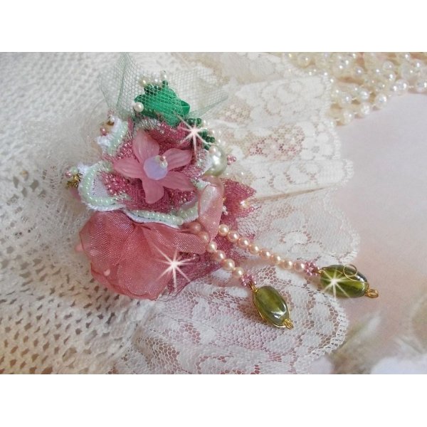 Broche de polvo suave creado con encaje, cinta de organza, cuentas de Swarovski, cuentas de cristal y cuentas de rocalla 