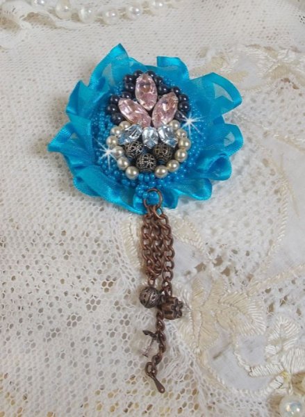 El broche Belle Epoque Haute-Couture est&aacute; bordado con cristales de Swarovski, perlas redondas, dijes, cinta y cuentas de rocalla