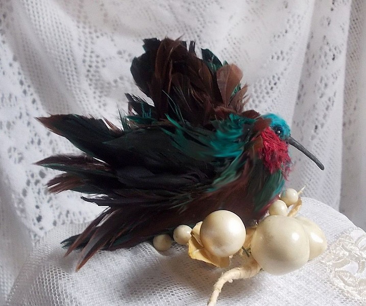 Le Colibri Thalassin cr&eacute;e enti&egrave;rement en porcelaine, des plumes de Coq et Fantaisies, des petites rocailles