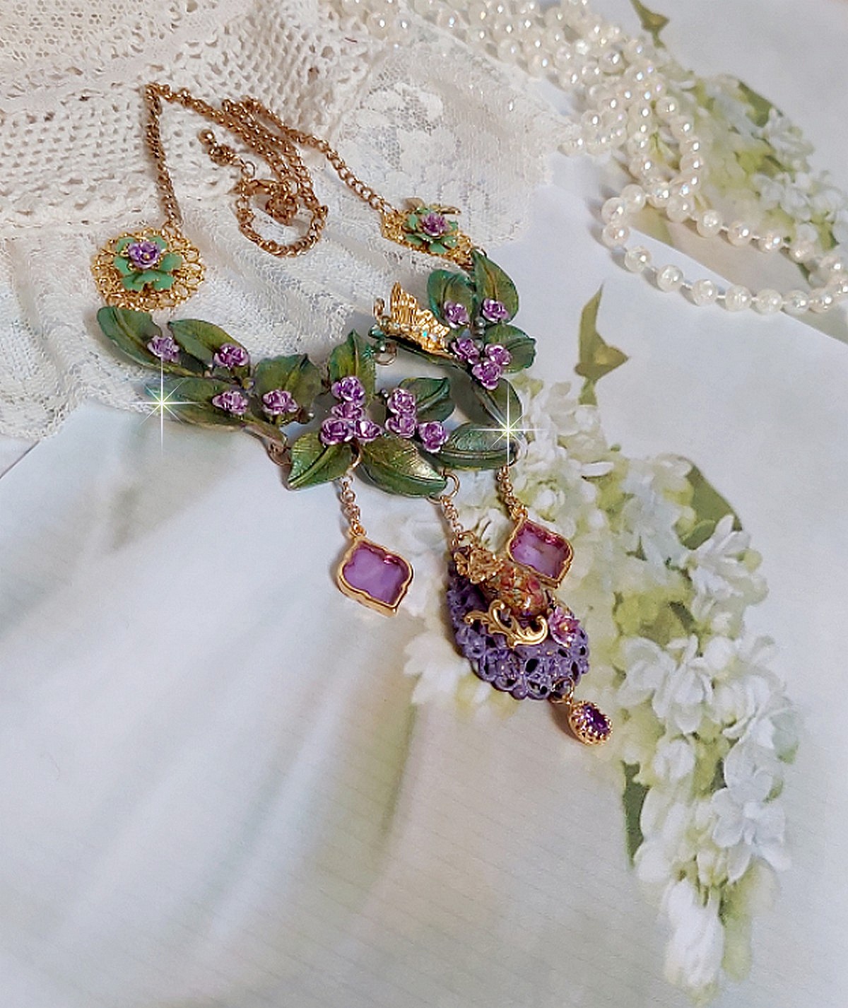 Collier Cam&eacute;lia Japonica mont&eacute; avec un motif feuilles aquarell&eacute;s &agrave; la main, paillettes, breloques papillons et abeille, roses m&eacute;tal, cabochon cristal, pendentifs &eacute;poxy aux couleurs d&rsquo;arc en ciel