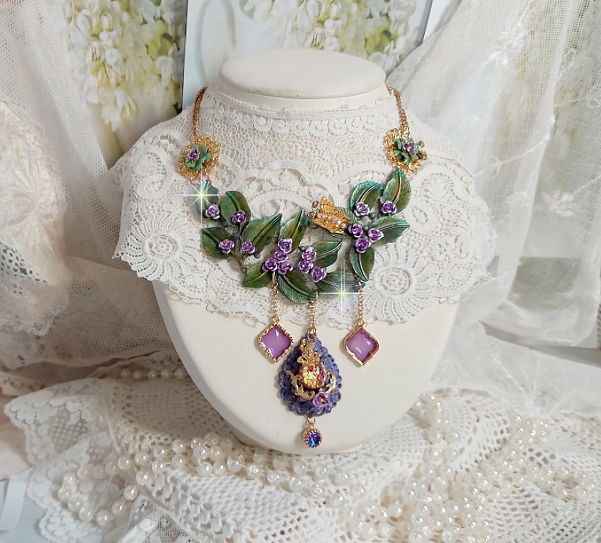 Collier Camélia Japonica monté avec un motif feuilles aquarellés à la main, paillettes, breloques papillons et abeille, roses métal, cabochon cristal, pendentifs époxy aux couleurs d’arc en ciel