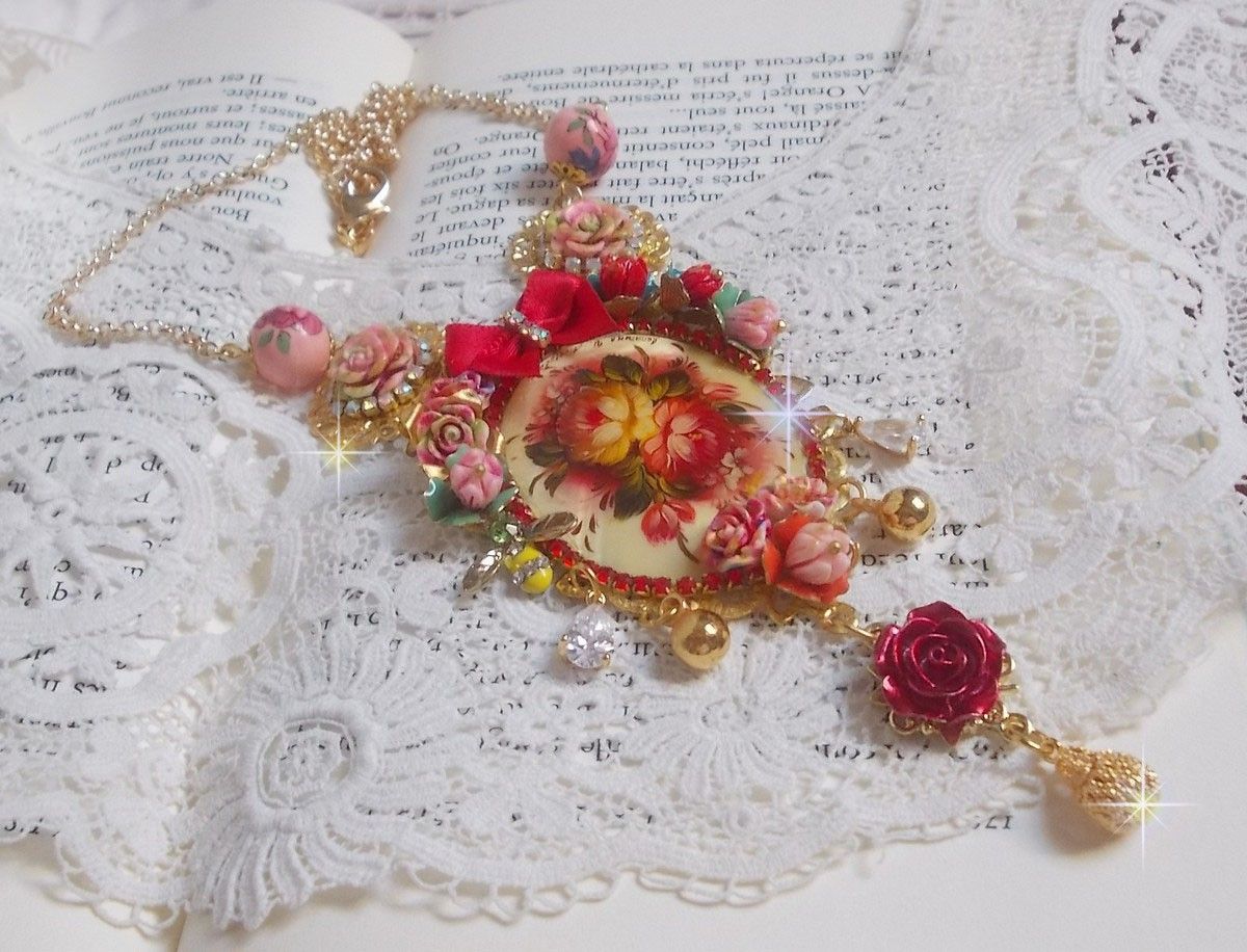 Collier Roseraie Provençale crée avec des perles en verre, céramique, résine, des accessoires en plaqué Or et autres avec un nœud en satin Rouge