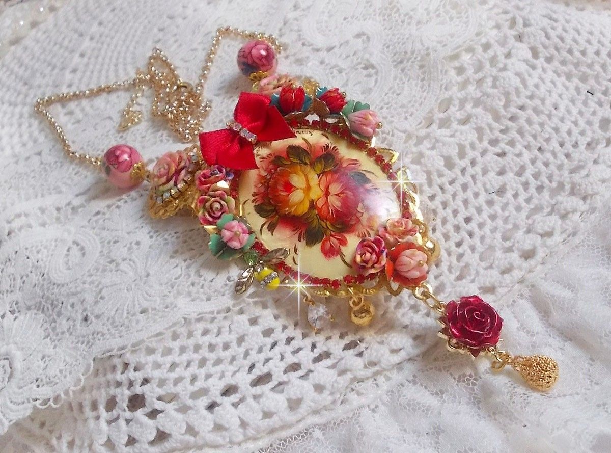 Collier Roseraie Provençale crée avec des perles en verre, céramique, résine, des accessoires en plaqué Or et autres avec un nœud en satin Rouge