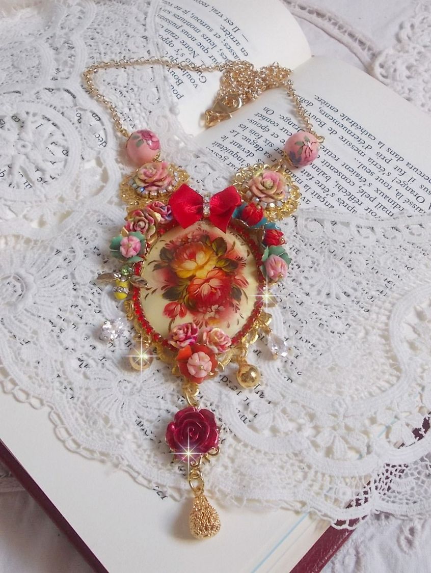 Collier Roseraie Provençale crée avec des perles en verre, céramique, résine, des accessoires en plaqué Or et autres avec un nœud en satin Rouge