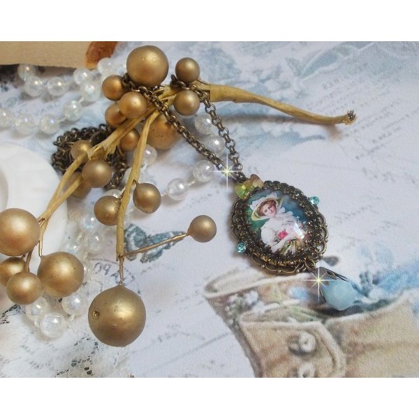 Pendentif Douce Dame cr&eacute;&eacute; avec un cabochon repr&eacute;sentant une femme au chapeau blanc orn&eacute; de cristaux, des accessoires de couleur Bronze et un jade teint&eacute; bleu 