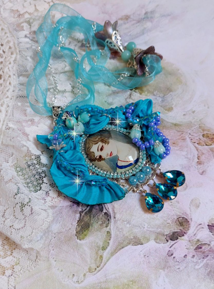 Pendentif Mademoiselle au style rétro avec cabochon d’une femme souriante, orné d’un ruban de soie Bleu, cristaux, perles verre : rocailles et roses, coupelles et chaîne Argent 925/1000