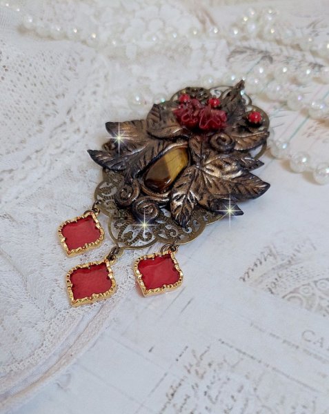 Pendentif M&eacute;lodie avec un cabochon &OElig;il de tigre orn&eacute; de perles en Jade Rouge vein&eacute; de Noir sur fleurs 5 p&eacute;tales et estampes mont&eacute;s sur une cha&icirc;ne bronze. Les pendants sont en r&eacute;sine &eacute;poxy Rouge