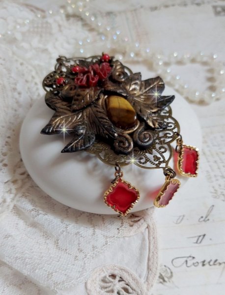 Pendentif M&eacute;lodie avec un cabochon &OElig;il de tigre orn&eacute; de perles en Jade Rouge vein&eacute; de Noir sur fleurs 5 p&eacute;tales et estampes mont&eacute;s sur une cha&icirc;ne bronze. Les pendants sont en r&eacute;sine &eacute;poxy Rouge