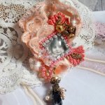 Broche Rosa rústica creado con un cabujón que representa una niña sonriente, strass naranja y encaje rosa, cristales, cuentas de vidrio y accesorios varios