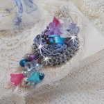 Colgante Mademoiselle Bluse Haute-Couture bordado con cristales de Swarovski, flores de resina, cuentas de perlas, cuentas de semillas y una cadena de plata 925