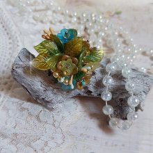 Bague Cézanne montée avec des petites fleurs lucites peintes à la main à laquelle s’ajoute des feuilles, cristaux, perles, étamines, grosses rocailles, perles nacrées et métal sur une bague en Laiton