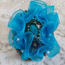 Ilycia Anillo con encanto bordado con un cabujón facetado de resina azul turquesa y una cinta de organza