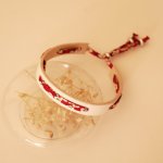 Pulsera Florâme con cinta liberty roja Misti sobre cuero blanco