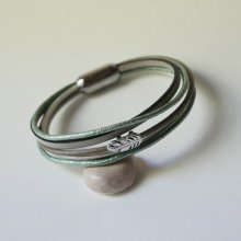 Pulsera multicuero en tonos beige, verde pálido y nacarado, decorada con una pequeña pluma
