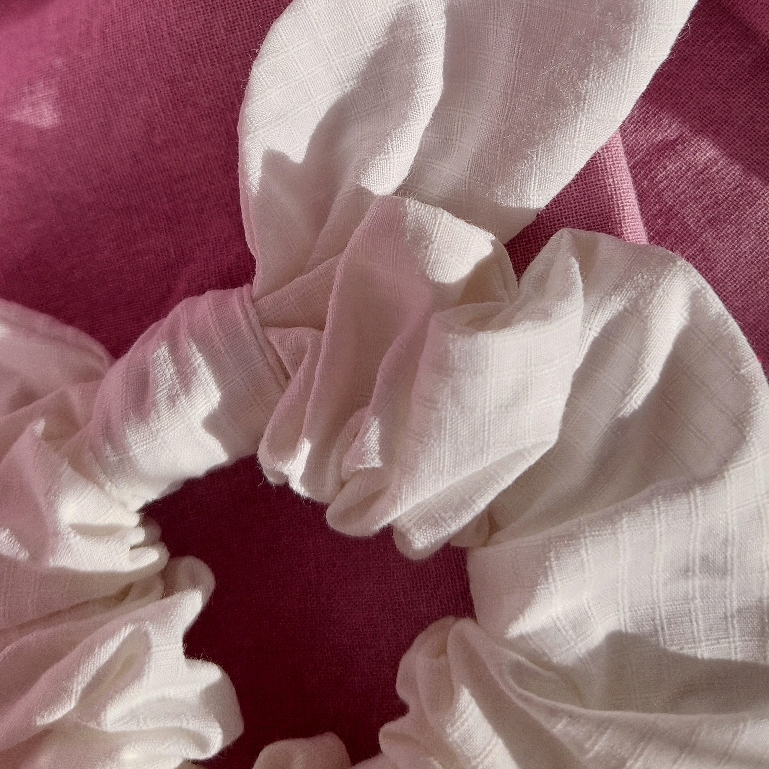 Chouchou foulchie blanc à carreaux sur fond rose.