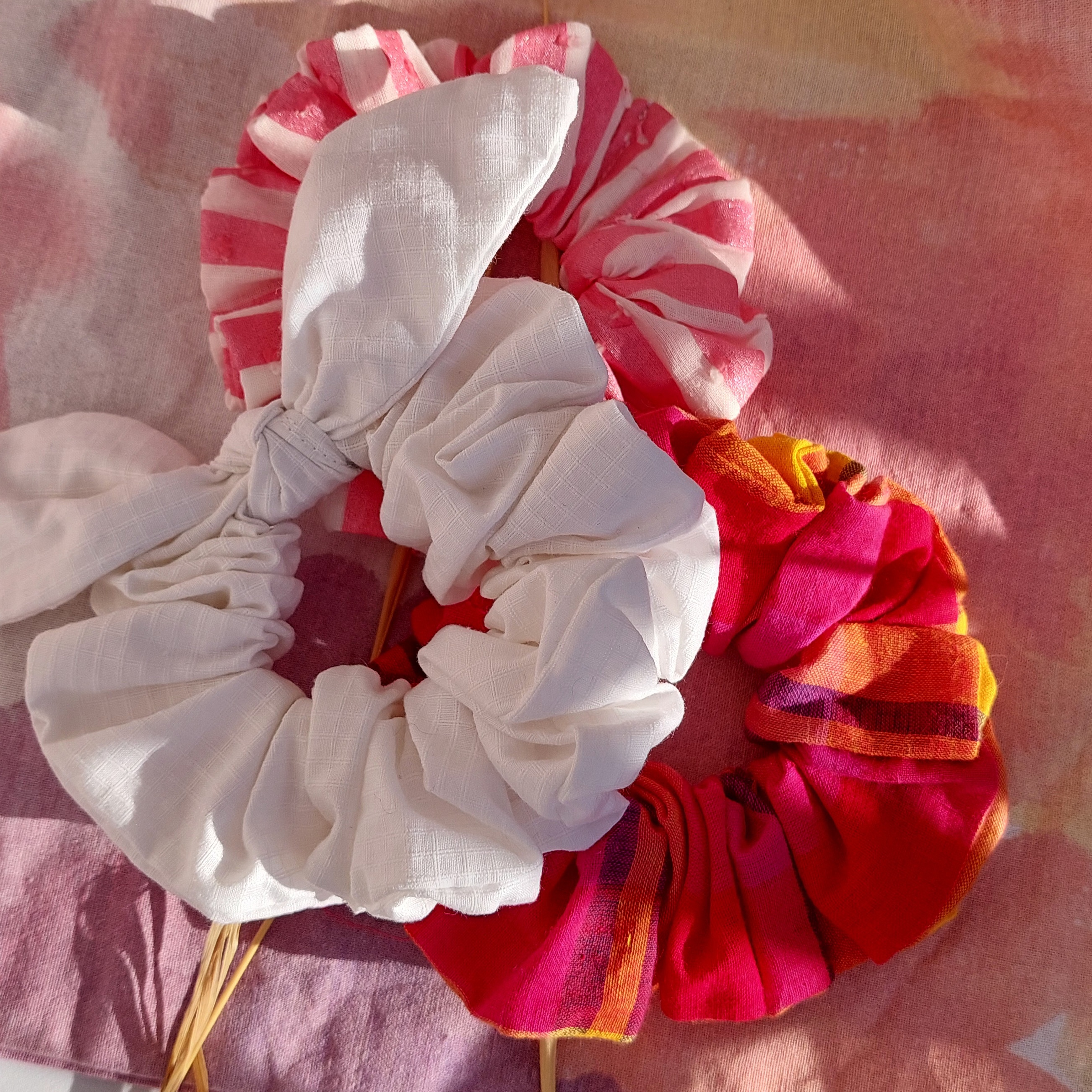 Chouchou foulchie blanc à carreaux sur fond rose.